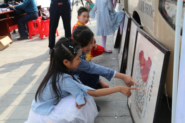 4月21日,恩施州公共图书馆阅读推广联盟巡展现场,市民小学生在认真观看读书漫画展