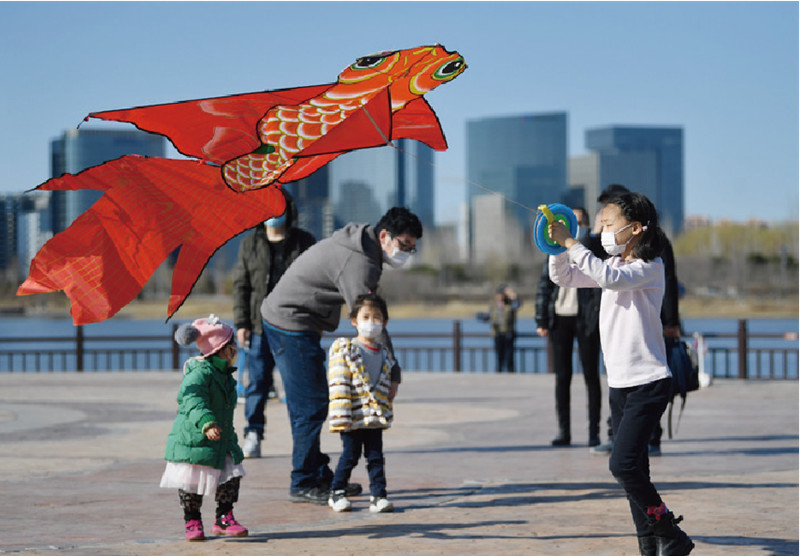 2020年3月15日,北京通明湖公园,做好防护措施的市民在放风筝.