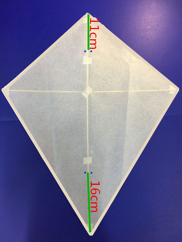 将风筝骨架用胶布粘到菱形纸上固定6个点.