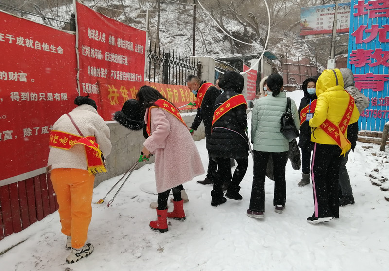 在支部领导的带领下,志愿者冒雪手持保洁工具、垃圾袋等工具,把图书馆周边的果皮、烟头、生活垃圾以及杂物等进行清洁1