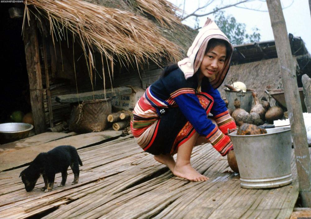 1999年,云南西双版纳美丽的基诺族姑娘和小狗